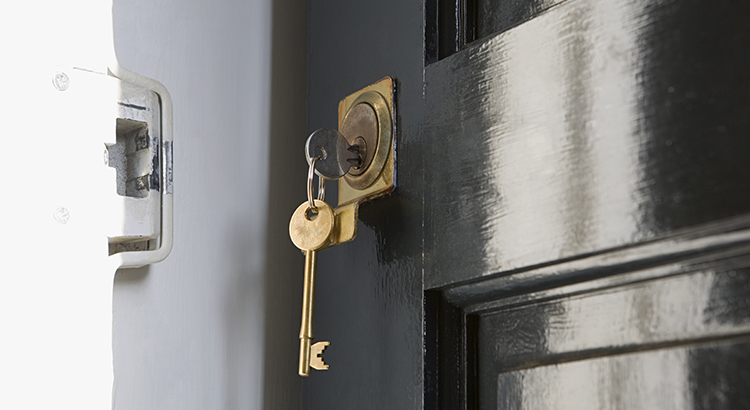 Gold key in door handle of black front door