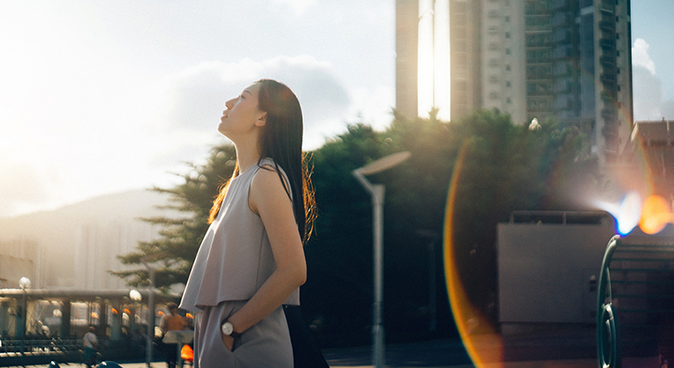 woman stands outside looking off in distance